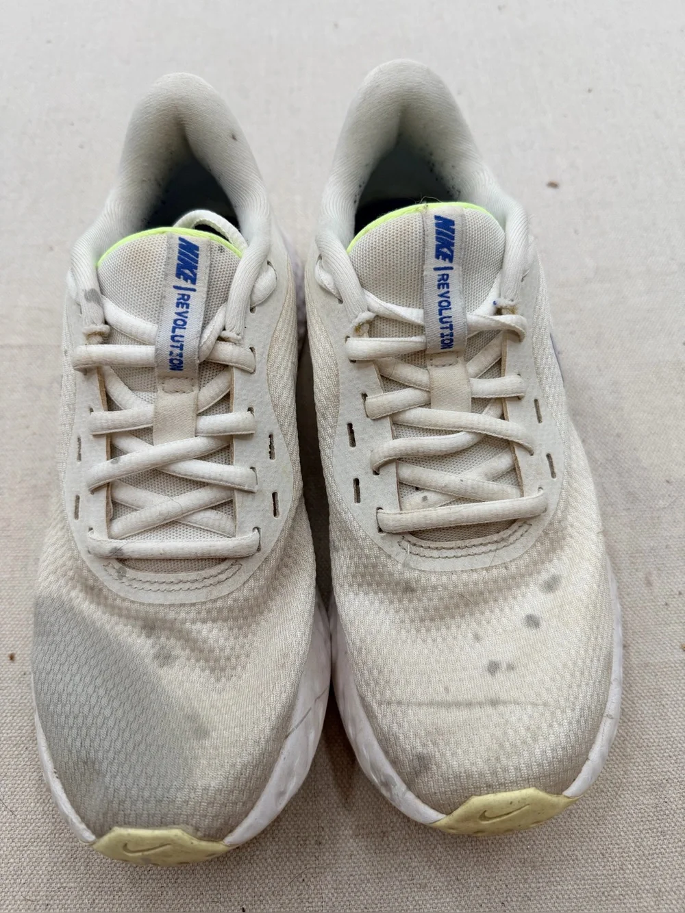 Nike Women’s Revolution Sneakers in Cream with Light Purple Swoosh
